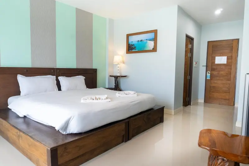 Une chambre lumineuse avec un grand lit recouvert de draps blancs.