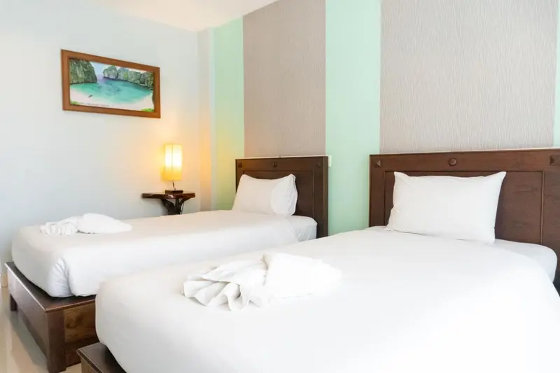 Une chambre lumineuse avec deux lits simples et une décoration sobre.