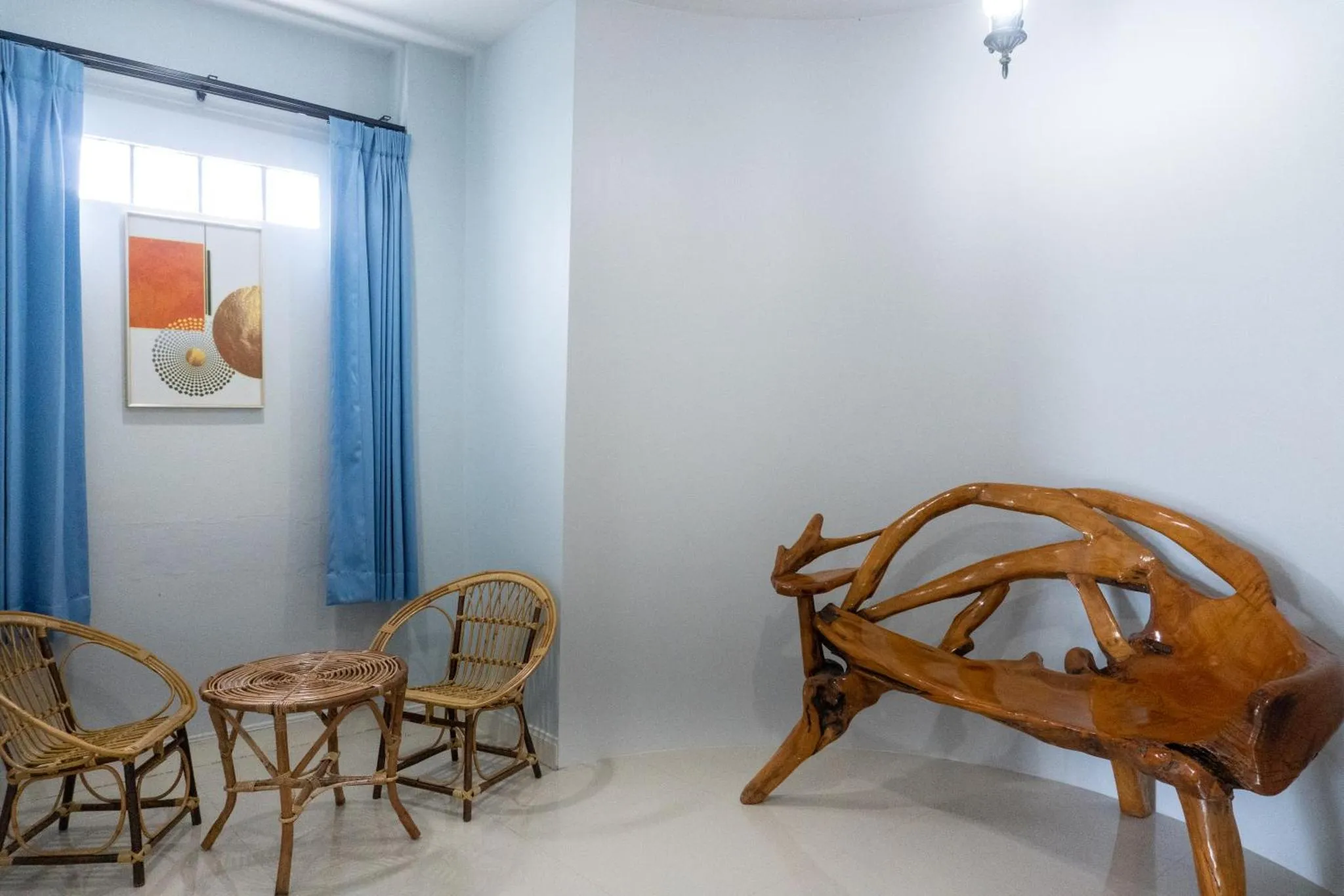 Espace de détente intérieur avec mobilier en bois et rideaux bleus.