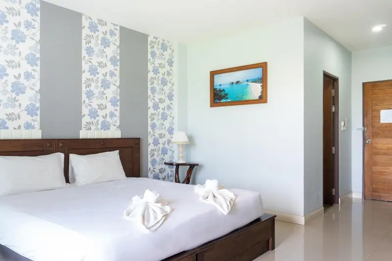Une chambre lumineuse avec un grand lit et une décoration florale.