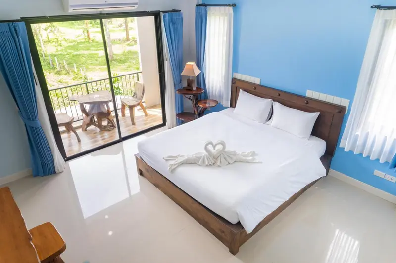 Une chambre lumineuse avec un lit double et un accès à une terrasse.