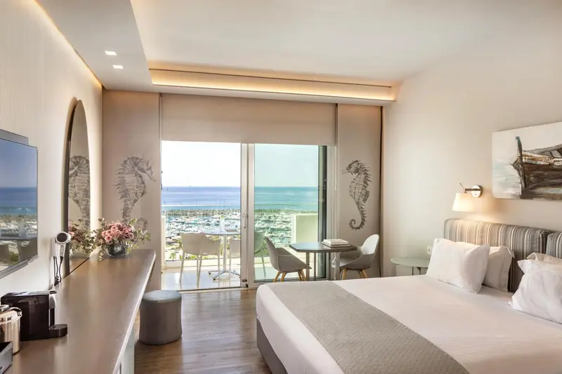 Une chambre lumineuse avec un lit double et une vue sur la mer.