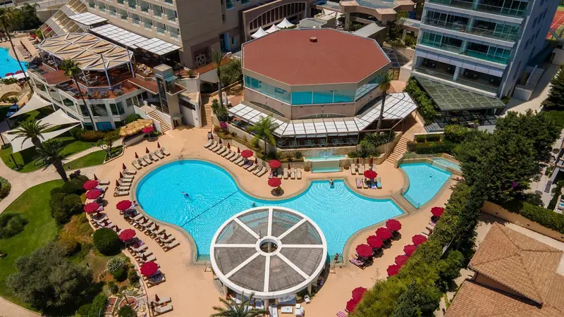 Vue aérienne d'un complexe hôtelier avec piscines et terrasses.