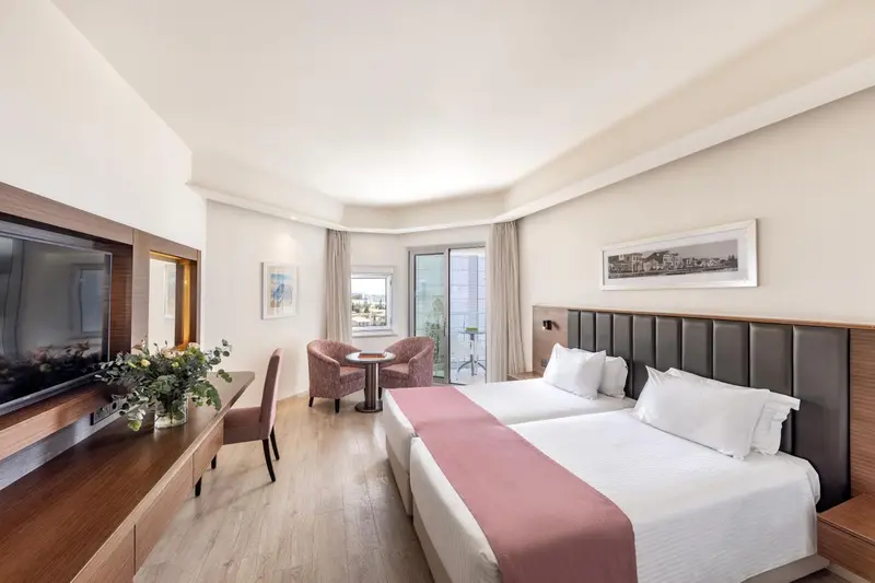 Une chambre lumineuse avec un lit double et un coin salon.