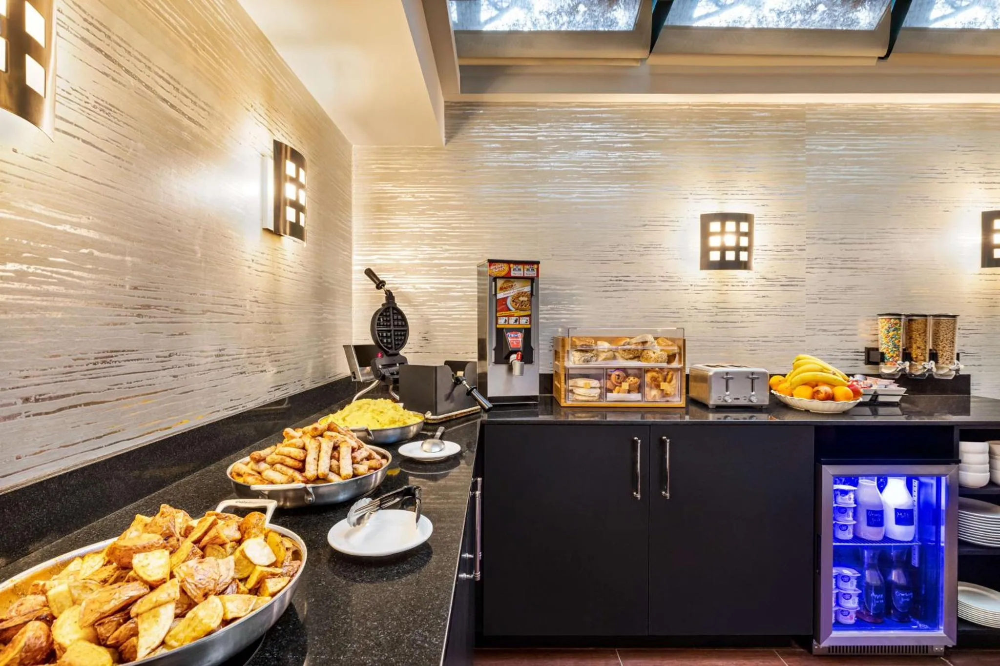 Un buffet propose des viennoiseries, des fruits et des boissons.