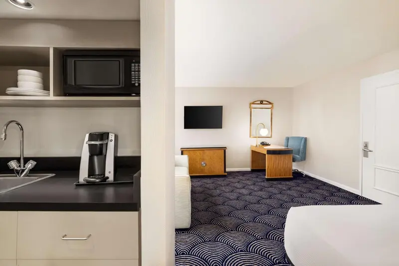 Une kitchenette et un bureau dans une chambre d'hôtel.