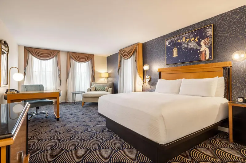 Une chambre d'hôtel lumineuse avec un grand lit et un coin salon.