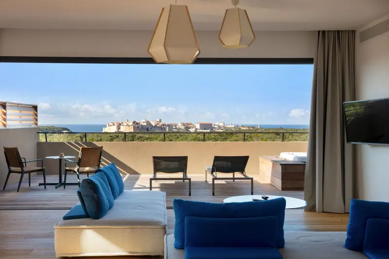 Espace de détente intérieur avec vue sur la mer et un paysage urbain.
