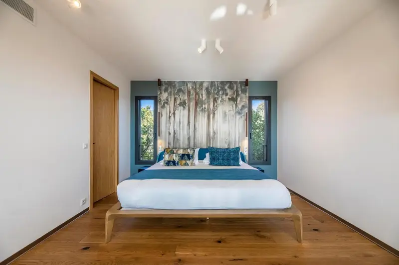 Une chambre lumineuse avec un grand lit et un mur décoratif.