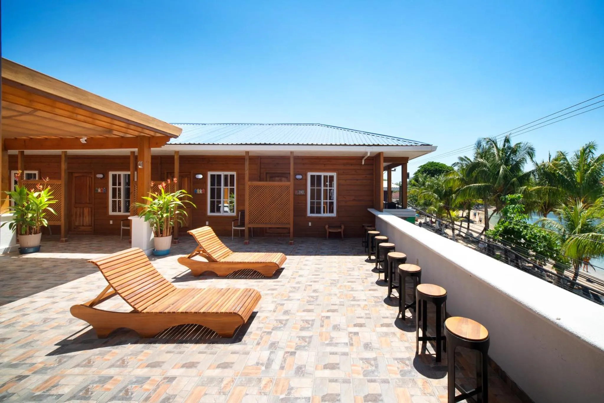 Terrasse en bois avec chaises longues et vue sur la mer.