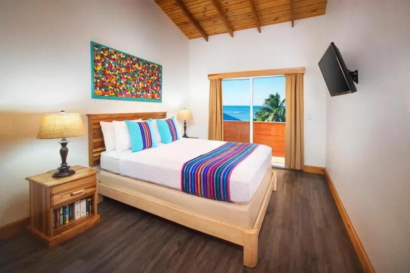 Une chambre lumineuse avec un grand lit et un accès à une terrasse.
