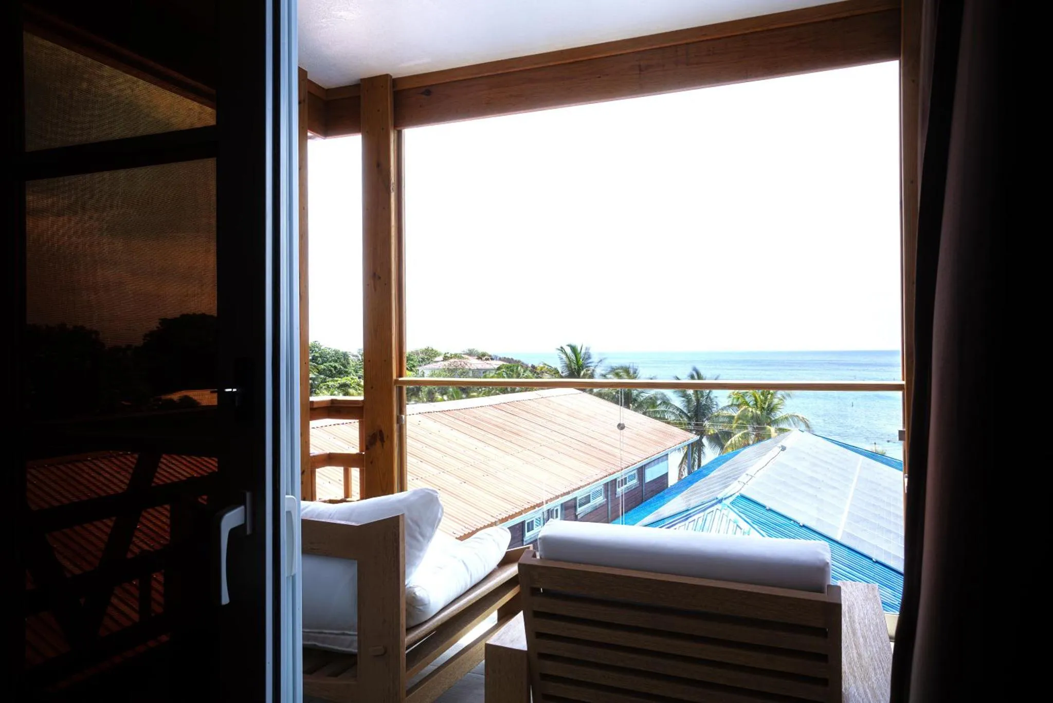 Vue sur la mer depuis une terrasse aménagée avec des fauteuils.