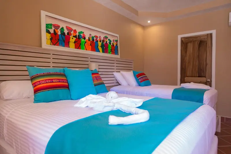 Une chambre lumineuse avec deux lits simples et une décoration colorée.