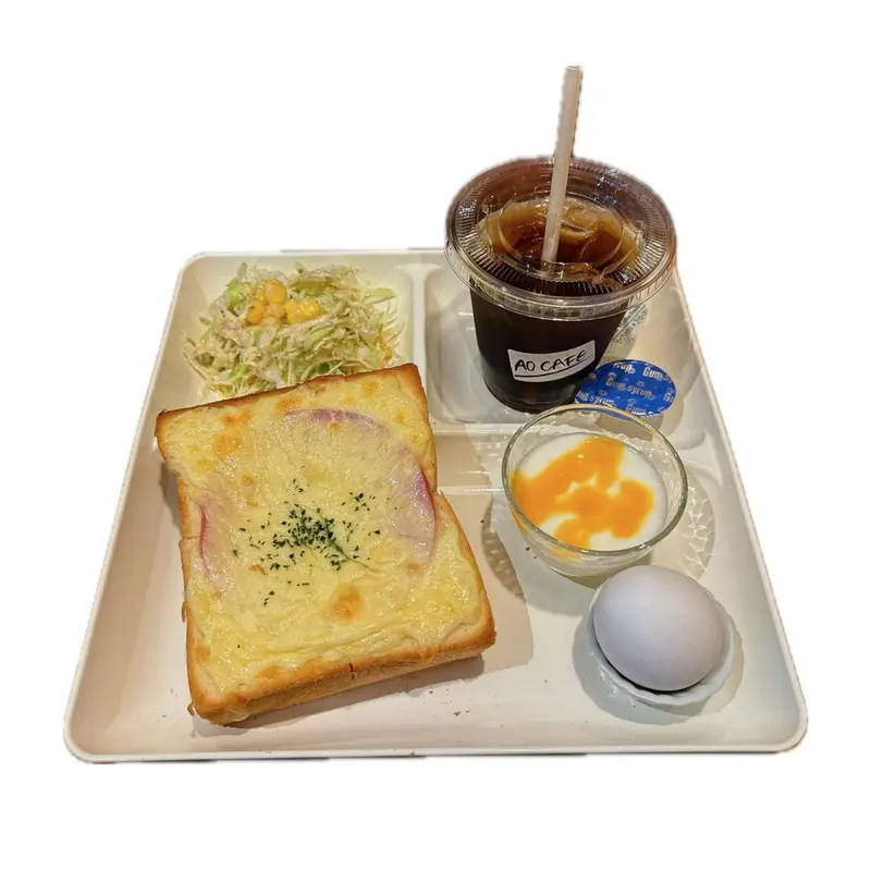 Assiette avec boisson glacée, salade, pain grillé et œuf.