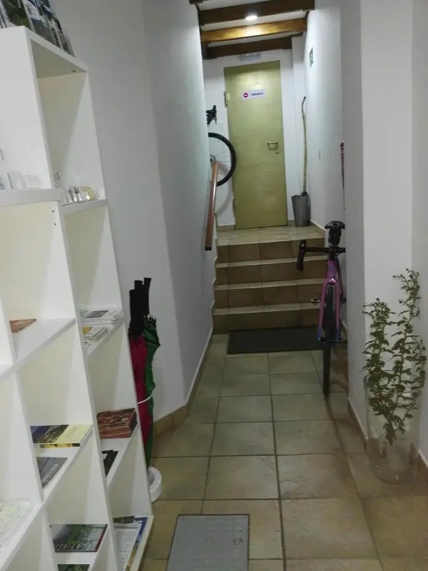 Un couloir intérieur mène à des escaliers et à des portes.