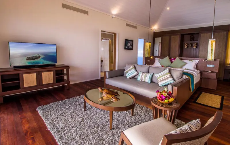 Espace de vie intérieur avec canapé, table basse et télévision à écran plat.