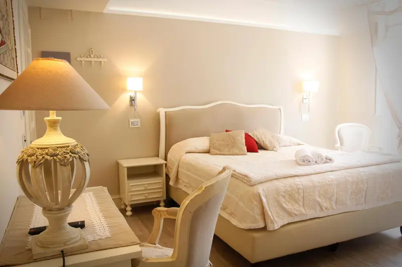 Une chambre lumineuse avec un lit à baldaquin et une lampe de chevet.