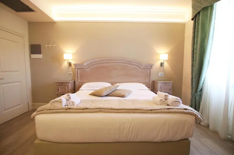 Une chambre lumineuse avec un grand lit recouvert d'une courtepointe et de coussins.