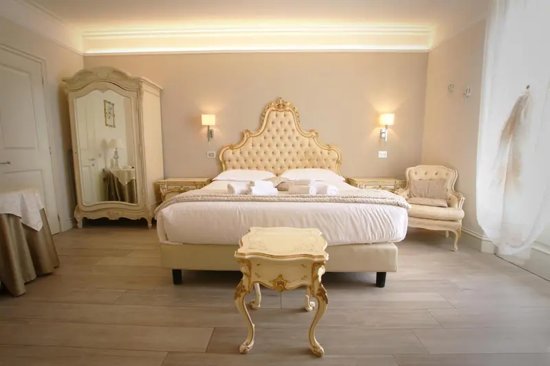 Une chambre lumineuse avec un grand lit à baldaquin et un mobilier ancien.