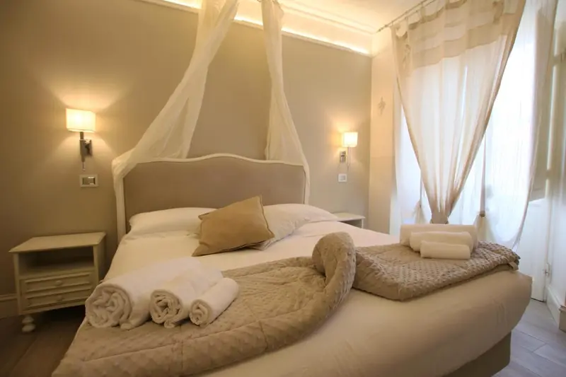 Une chambre lumineuse avec un grand lit recouvert de coussins et de couvertures.