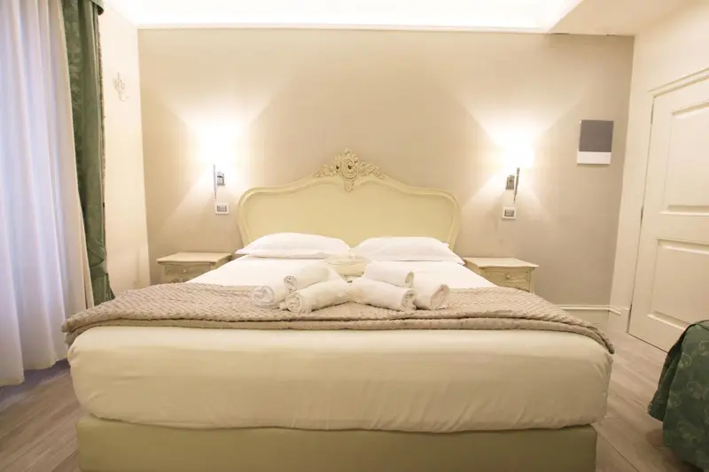 Une chambre lumineuse avec un grand lit à baldaquin et des tables de chevet.