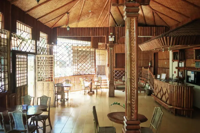 Espace intérieur lumineux avec mobilier en bois et comptoir de réception.