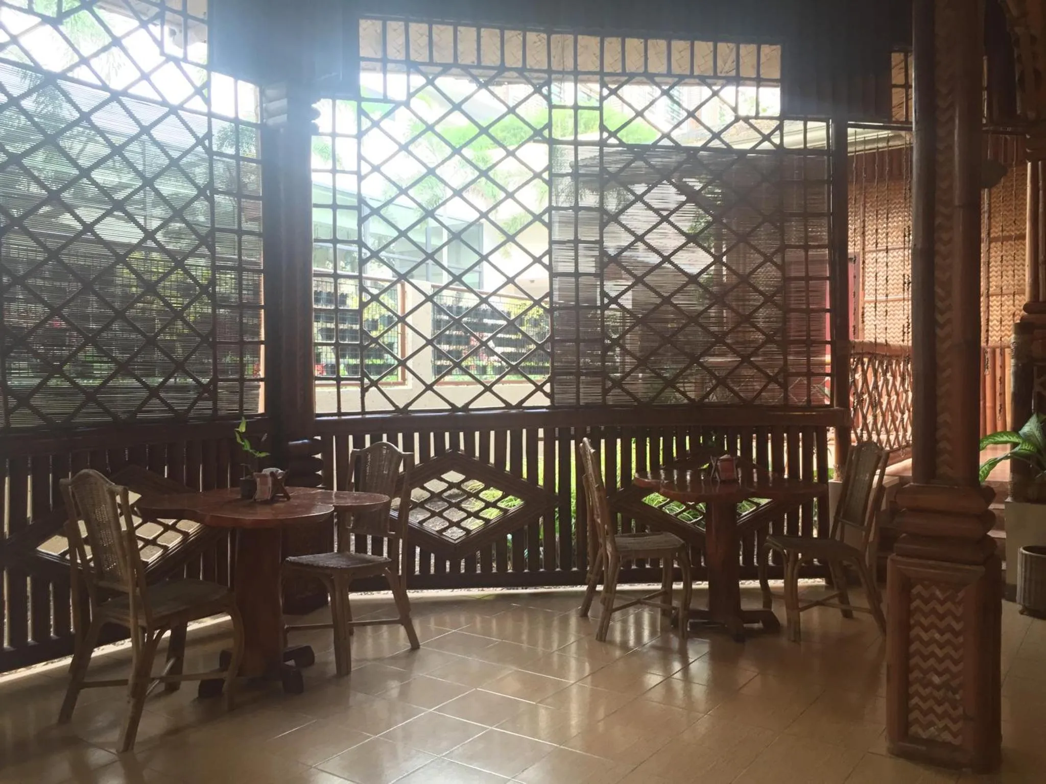 Une terrasse ombragée avec des tables et des chaises en bois.