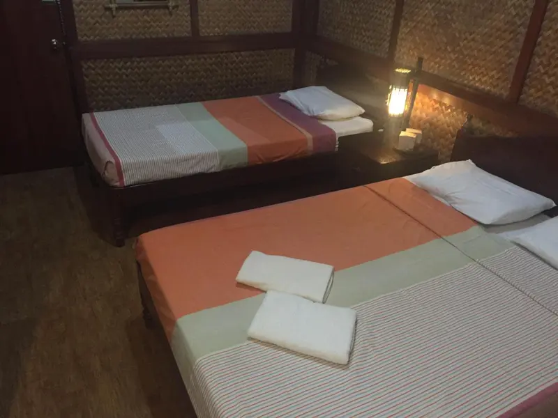 Chambre avec deux lits simples et une décoration en fibres naturelles.