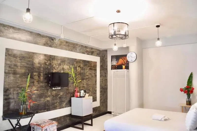 Une chambre lumineuse avec un grand lit et une décoration murale abstraite.