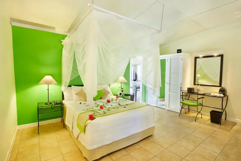 Une chambre lumineuse avec un lit à baldaquin et une décoration florale.