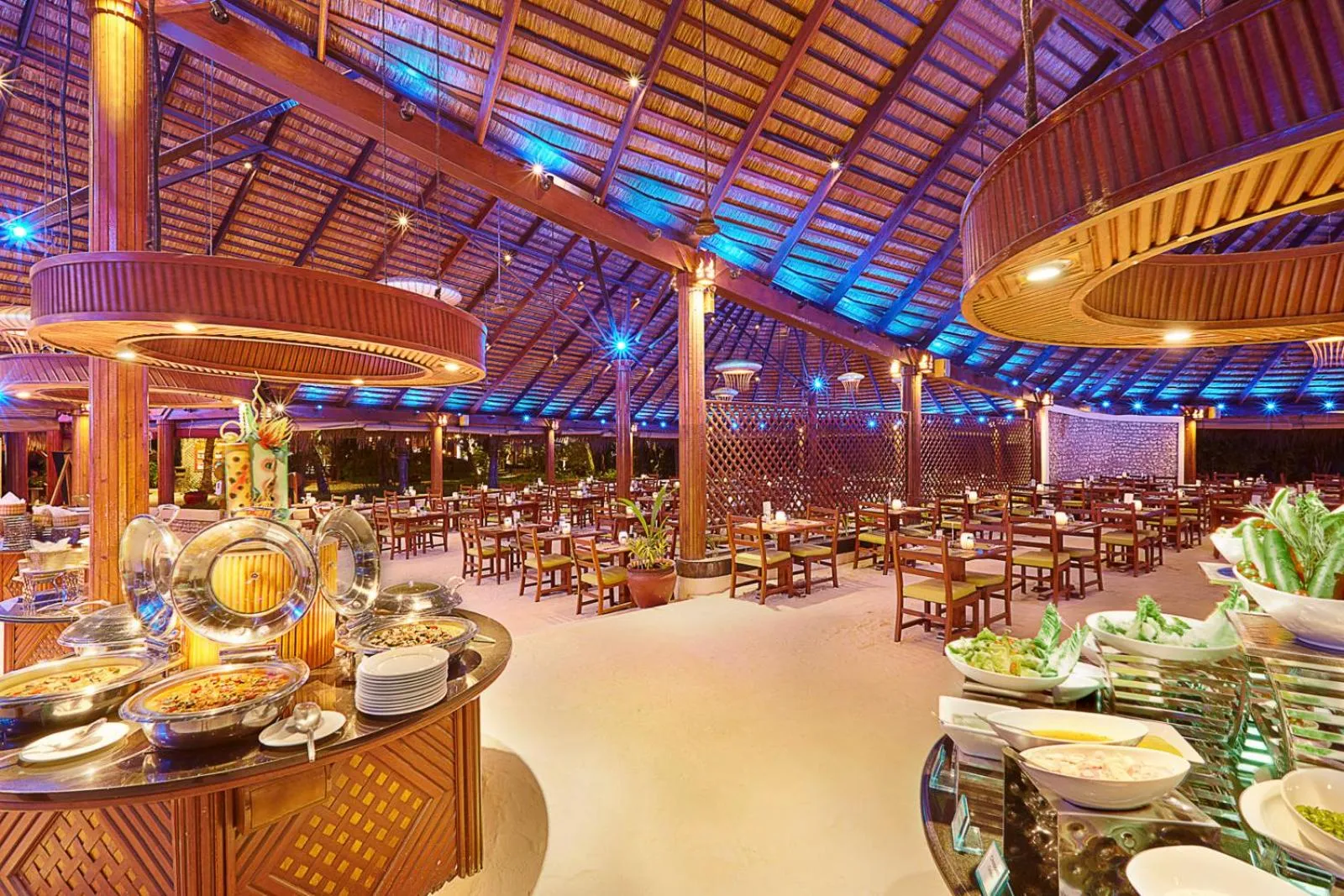 Un buffet de plats variés est présenté dans une salle à manger ouverte et lumineuse.