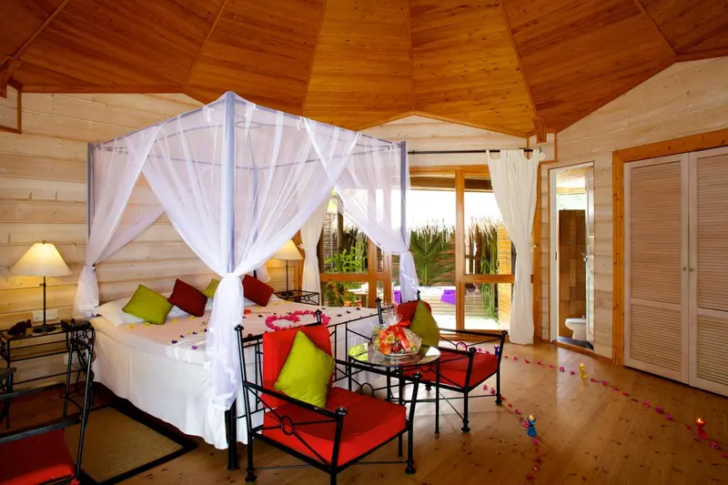 Une chambre avec un lit à baldaquin et une décoration florale.