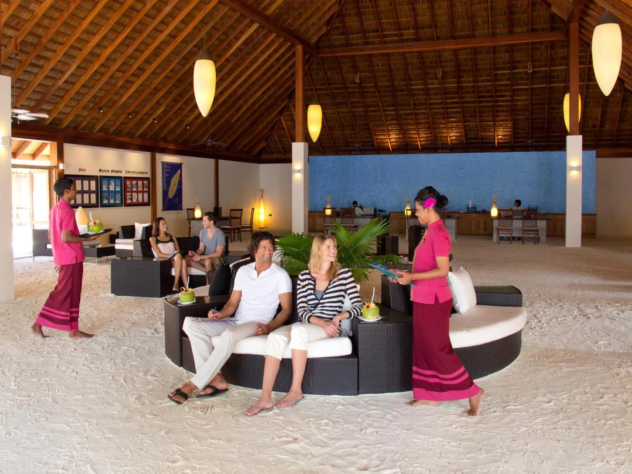 Des clients sont servis avec des boissons dans un espace de détente en bord de mer.