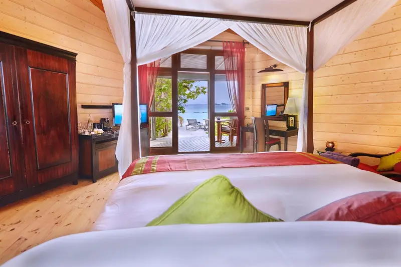 Une chambre lumineuse avec un grand lit et une vue sur une terrasse.
