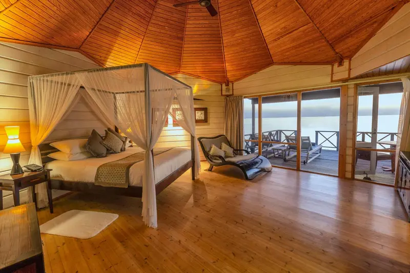 Une chambre spacieuse avec un lit à baldaquin donnant sur une terrasse.