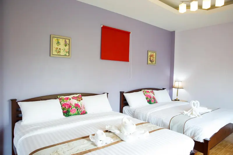 Une chambre lumineuse avec deux lits décorés de fleurs.