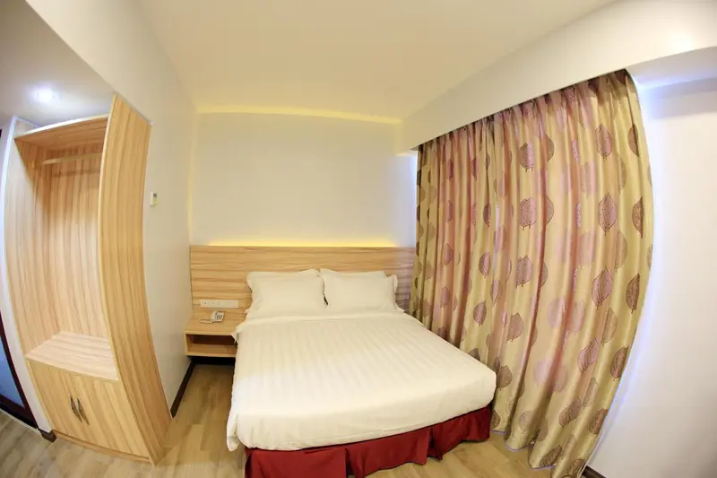Une chambre lumineuse avec un lit double et un grand placard.