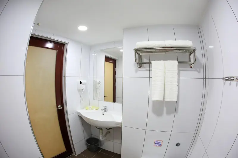 Une salle de bain claire avec lavabo et serviettes.