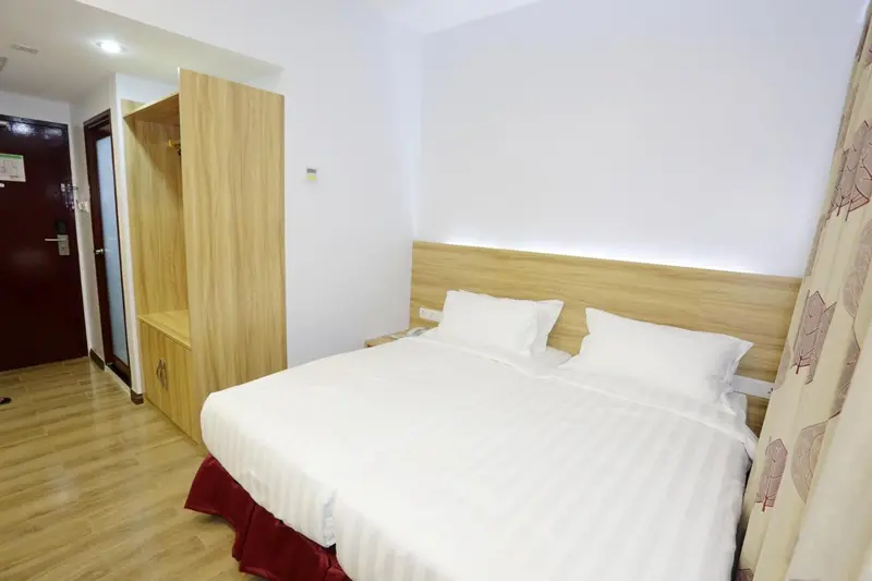 Une chambre lumineuse avec un lit double et un grand placard.