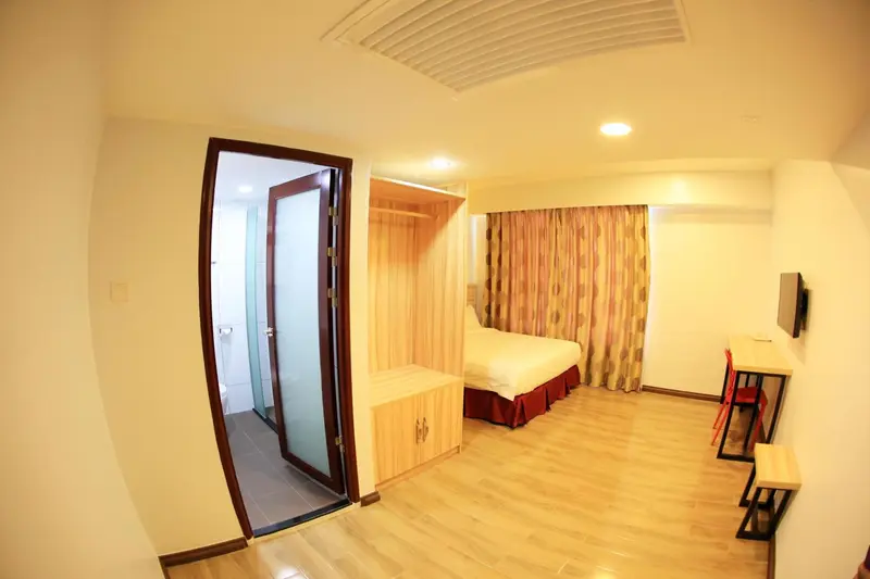 Une chambre d'hôtel lumineuse avec un lit et un accès à une salle de bain.