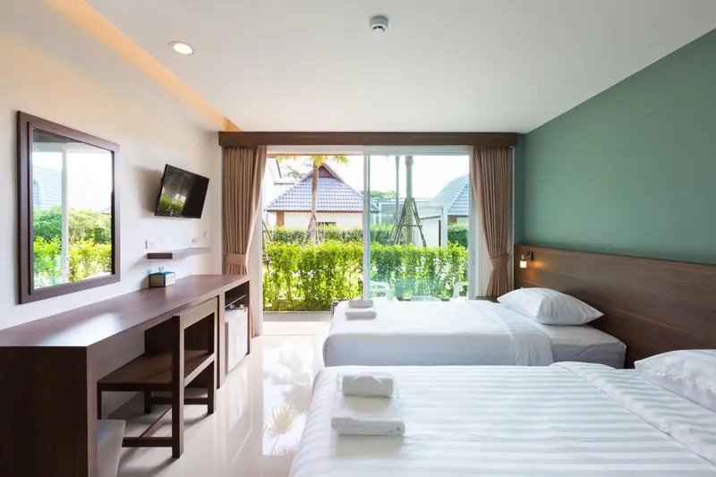 Une chambre lumineuse avec un lit et un accès à une terrasse.