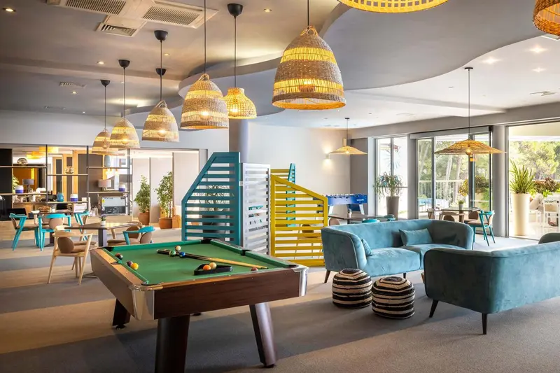 Espace de détente avec canapés, tables basses et billard.