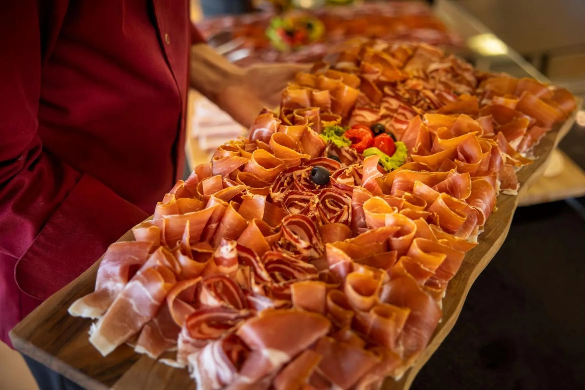 Présentation de charcuterie sur un plateau en bois.