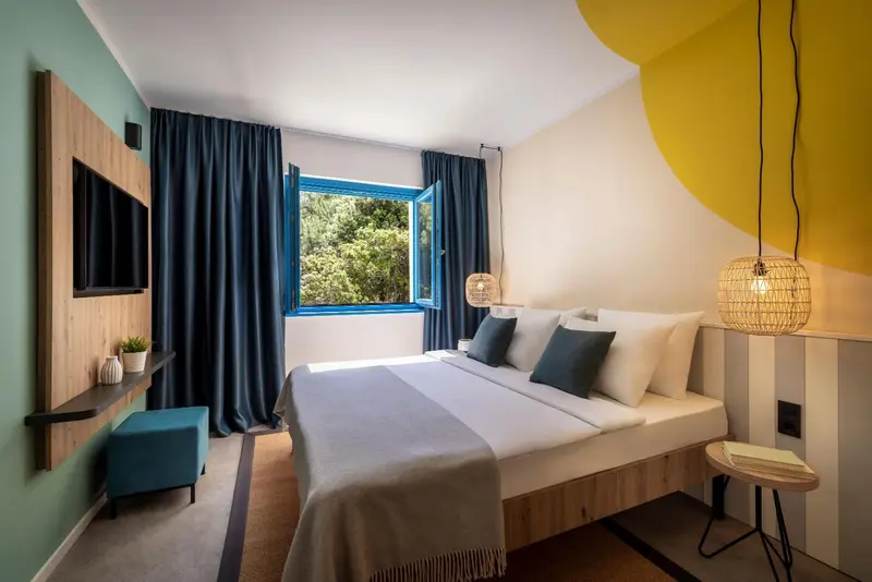 Une chambre lumineuse avec un lit double et une décoration moderne.