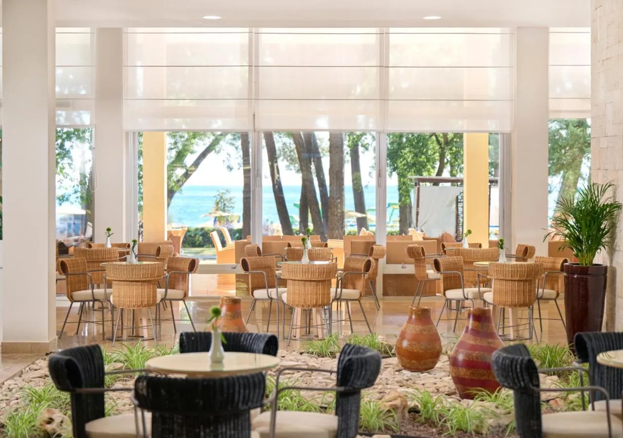 Espace de détente lumineux avec mobilier en rotin et vue sur la mer.