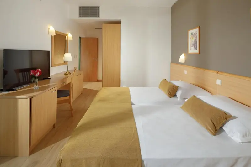 Une chambre lumineuse avec un grand lit et un bureau.