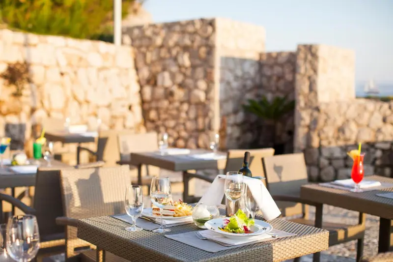 Tables dressées en terrasse avec des plats et des boissons.