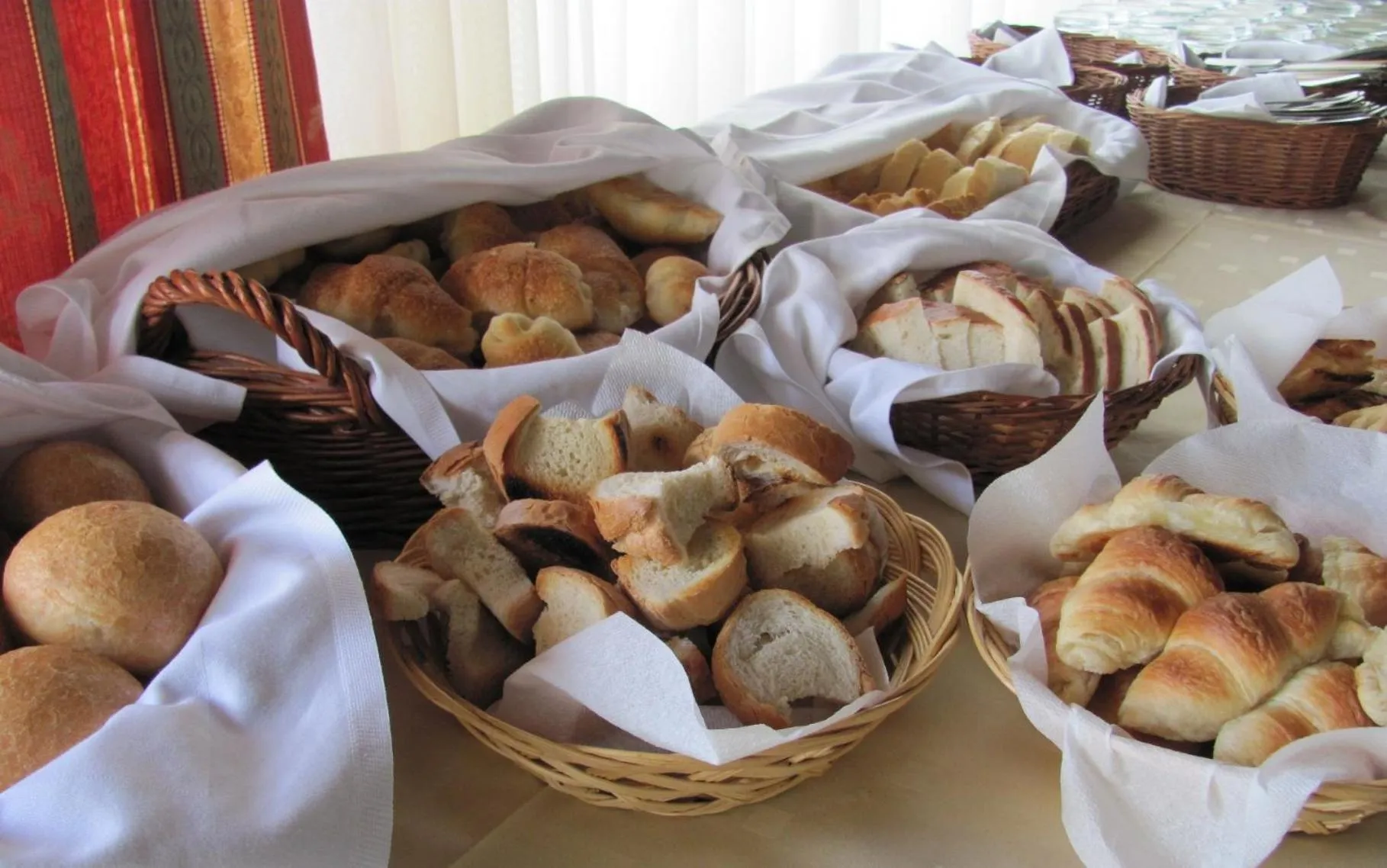 Assortiment de viennoiseries et de pains frais présentés dans des paniers.