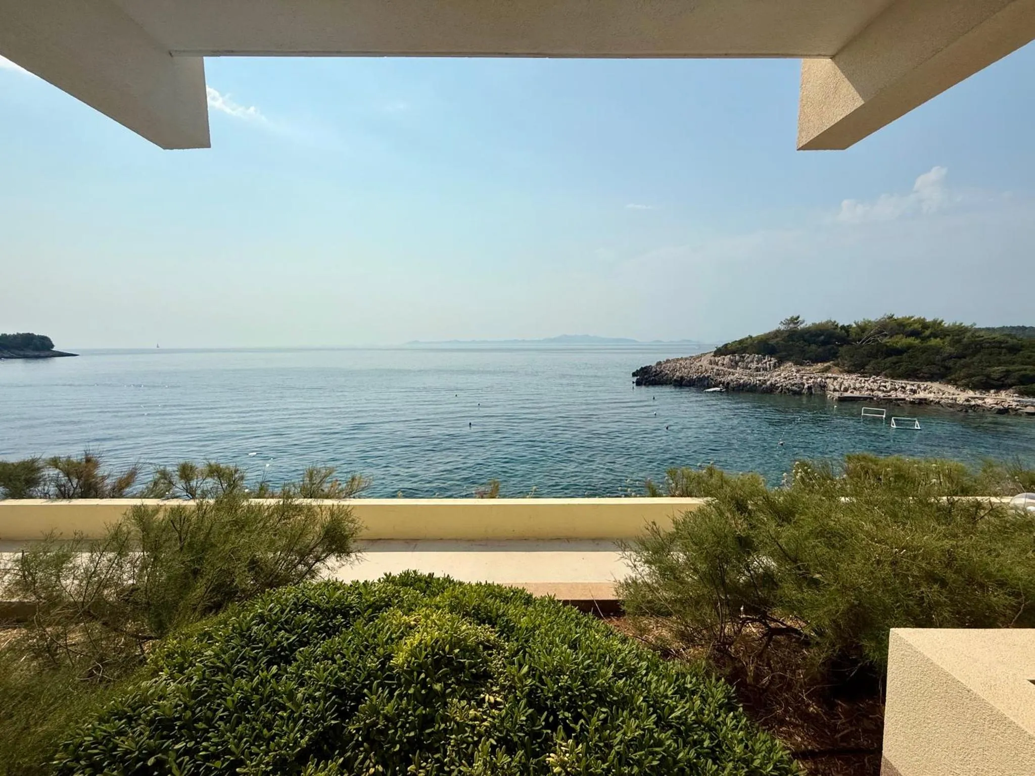 Vue sur la mer depuis une terrasse ensoleillée.
