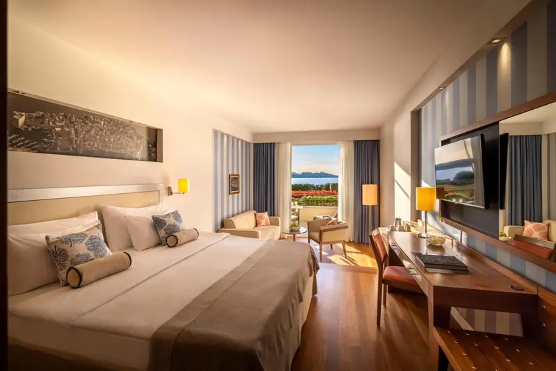 Une chambre lumineuse avec un grand lit et une vue sur la mer.
